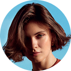 Circular portrait of a person with short hair on a plain background